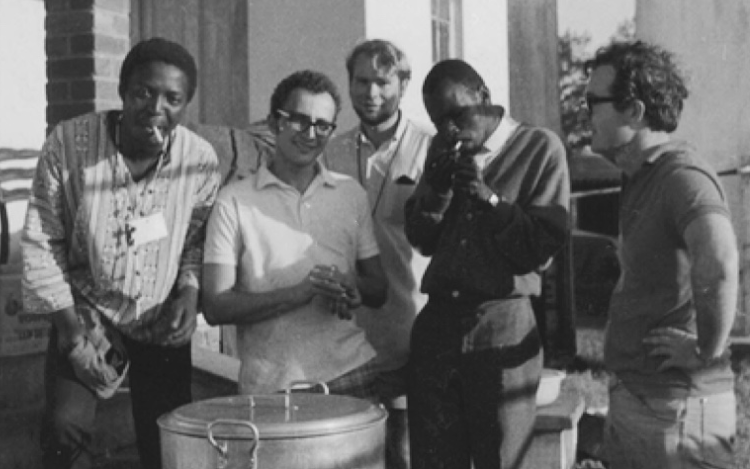 Steve Biko lighting up with Rick Turner (right), Dave Turnbull (centre) and volunteers who were helping restore the Mahatma Gandhi Ashram in Phoenix, Durban, 1971